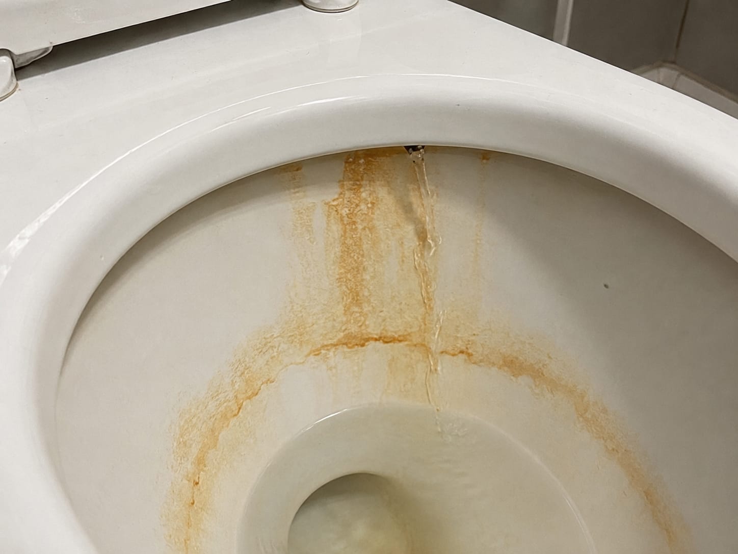 Agua oxidada tiñendo un lavamanos blanco